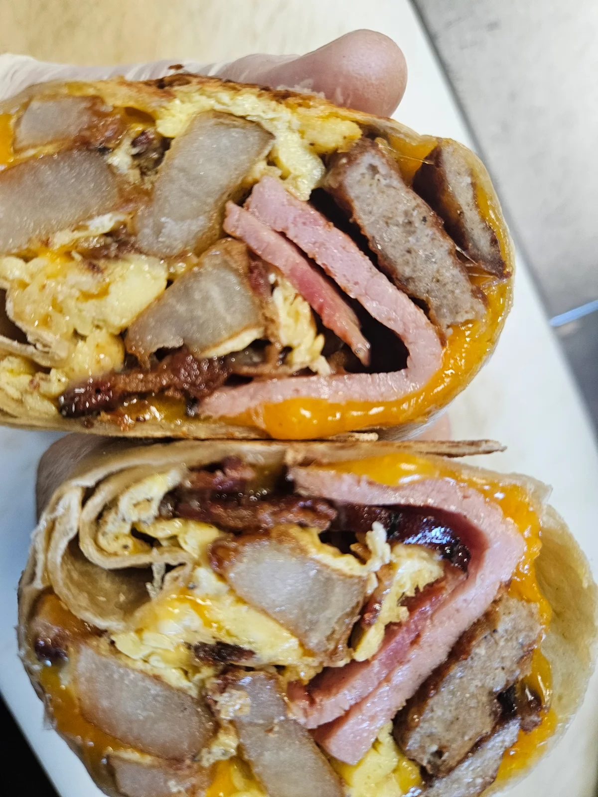 Carnivore Breakfast Burrito at Nerdateria — ham, sausage, bacon, egg and cheddar