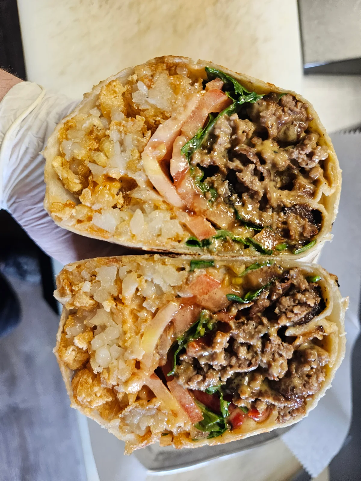 Chopped Cheese Burrito at Nerdateria — tater-tot stuffed with ground beef and cheese
